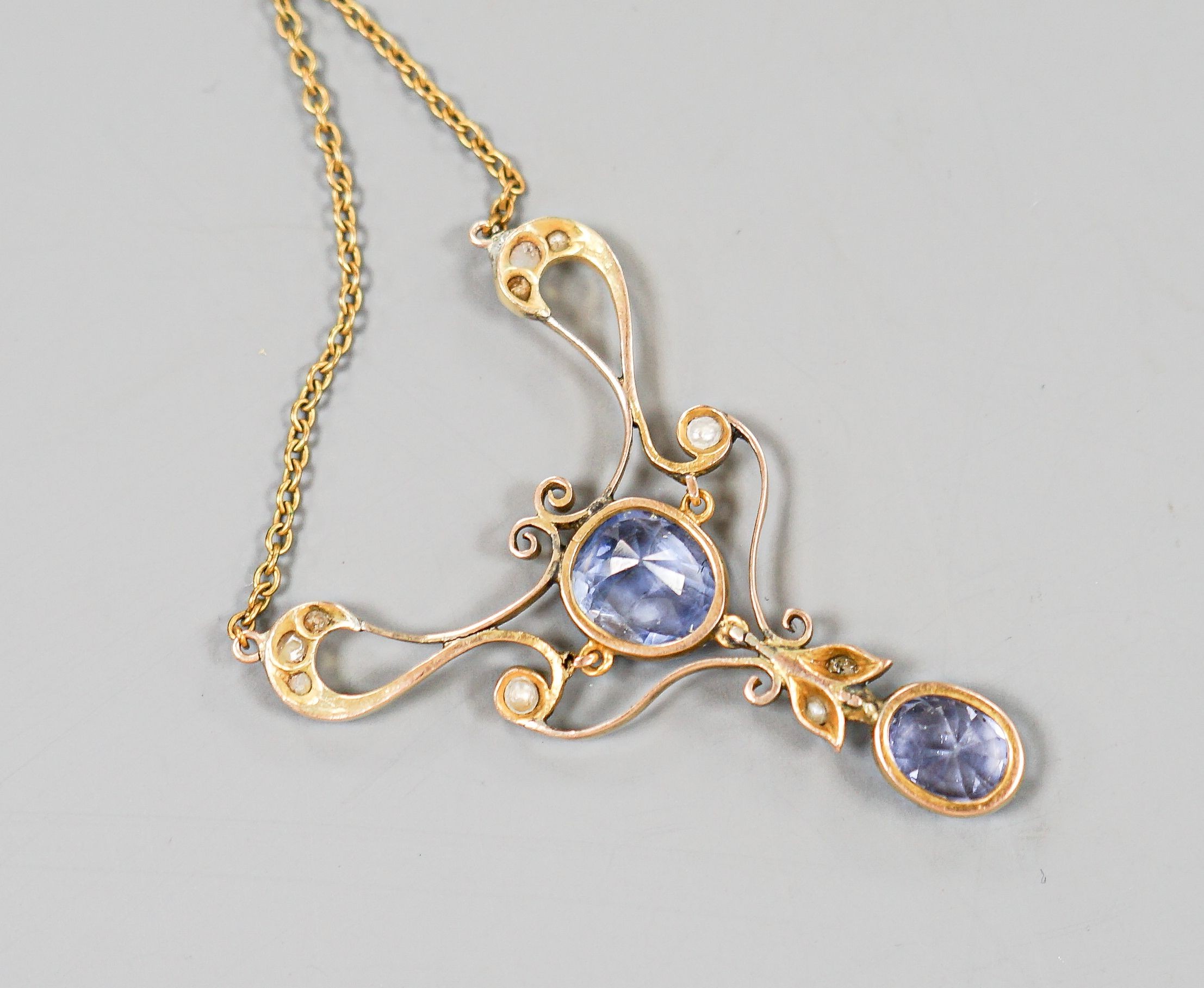 An early 20th century 9ct, two stone Ceylon sapphire and multi seed pearl set pendant necklace, pendant 49mm, chain approx. 40cm, gross weight 9.2 grams